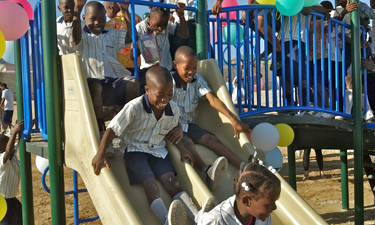 Haitian schoolchildren show the power of play on their donated playground from Kids Around the World.