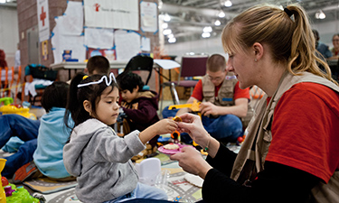 Four-year-old Didi plays with Save the Children staff member Sarah Thompson in the child-friendly shelter space set up at the Atlantic City Convention Center.