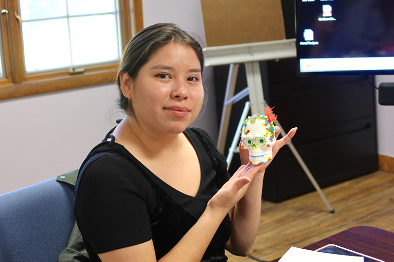 A participant shows her decorated sugar skull in preparation for Día de Muertos (Day of the Dead).