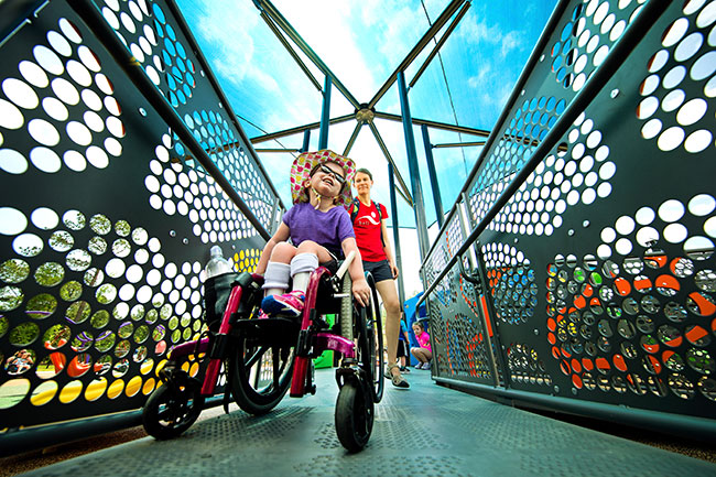 A child in a wheelchair explores a playground