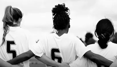 youth soccer players embrace on field
