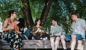 Adults sitting under tree at park
