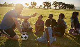 soccer coach talks to children