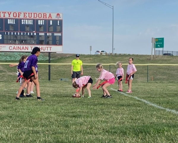 A group of young girls play flag football