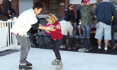 Volunteering at events is a great way for teens to tap into their skills and interests and give back to their community. Here, an Alameda Youth Committee member helps a girl practice skating skills.