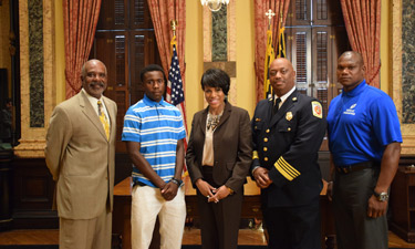 Philip Ellison, second from left, stands alongside Baltimore City officials as he is recognized for his heroic efforts.
